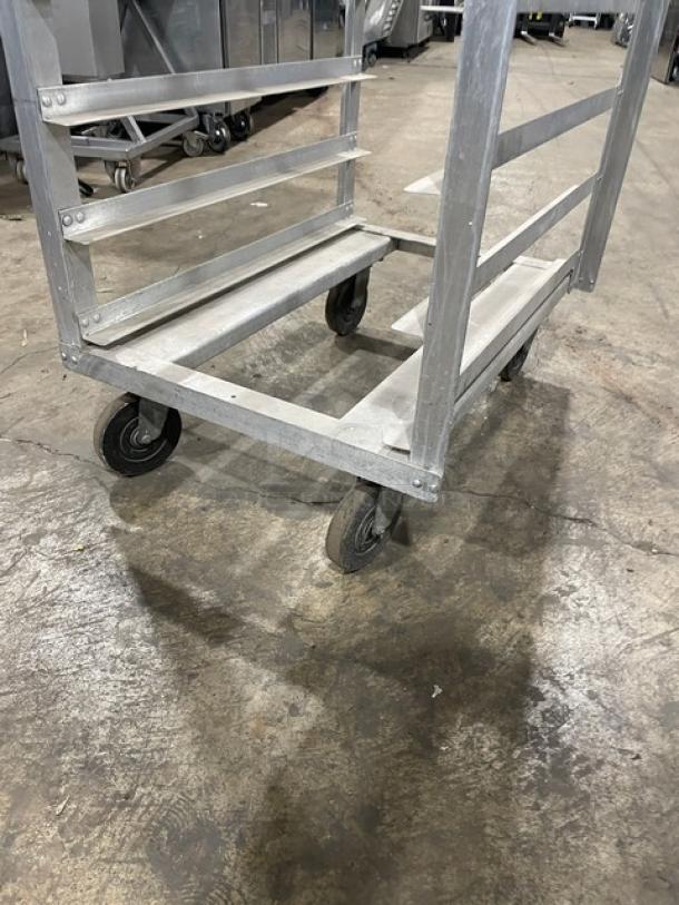 Commercial aluminum pan holding/transport rack on casters; includes multiple shelves, sturdy build, used condition.