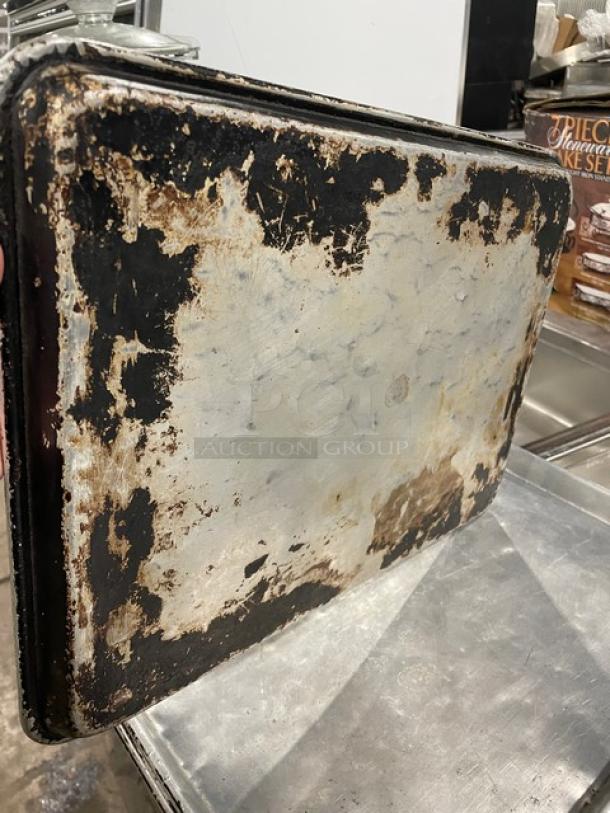 Worn commercial full-size sheet pan with visible rust and patina, showcasing heavy use. Ideal for restoration or industrial decor.