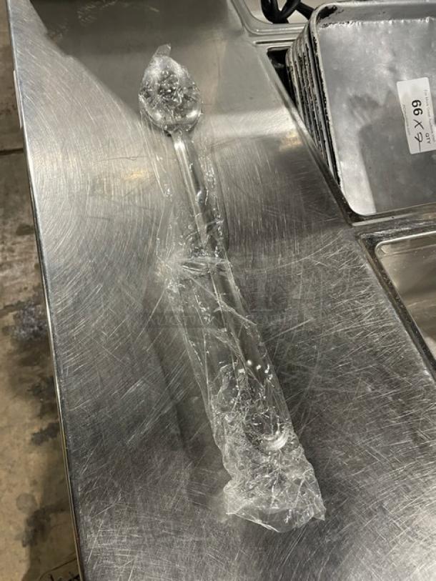 Brand new Update International 18" perforated basting spoon, model BSPF18HD, wrapped in plastic. Ideal for commercial use.