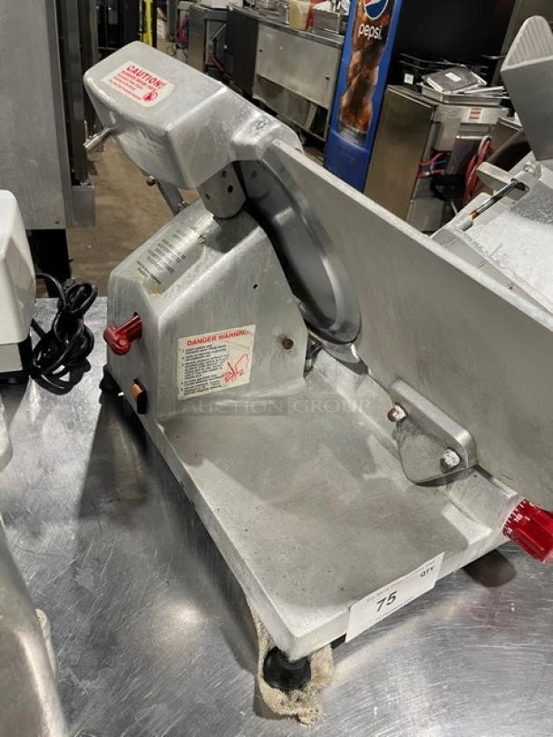 Fleetwood commercial electric meat slicer on legs, heavy-duty, countertop model. Visible caution labels and power switch.