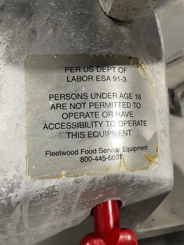 Fleetwood electric meat slicer, heavy-duty, countertop model with legs. Includes safety label: not for use by under 18.
