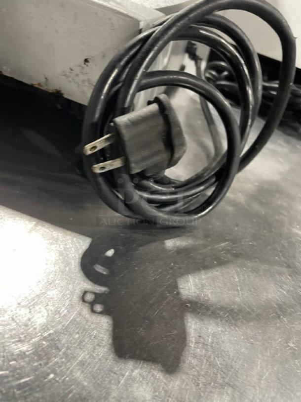 Fleetwood electric meat slicing machine cord on metal surface, showcasing plug and durable design.