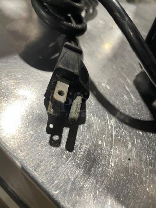 Vita-Mix VM0103 blender power plug on countertop, featuring standard three-prong plug, minor wear visible.