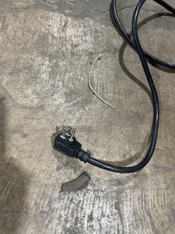 Black power cord with a three-prong plug for QBD Cooling Systems Model CD26HB refrigerator. Visible wear.