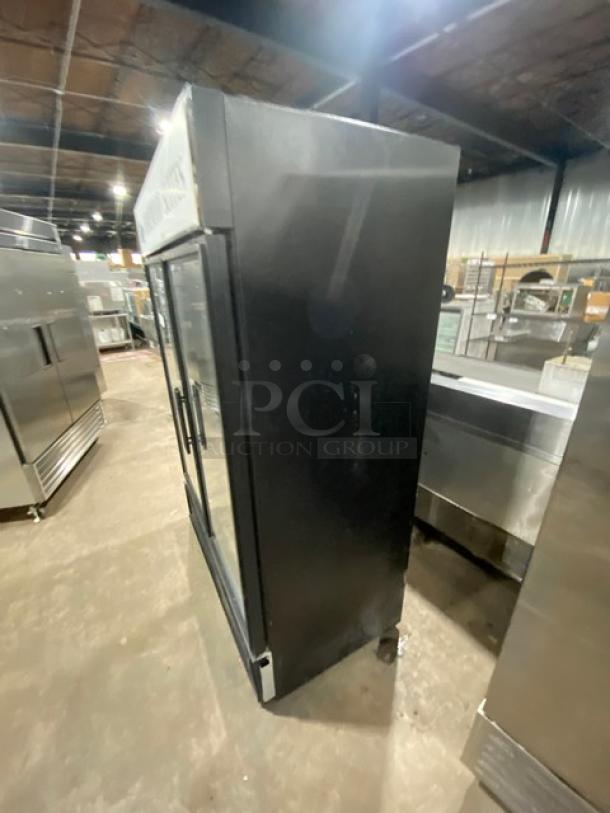 True GDM-49F commercial freezer, black, double glass swing doors, poly-coated wired racks, model visible, used condition.