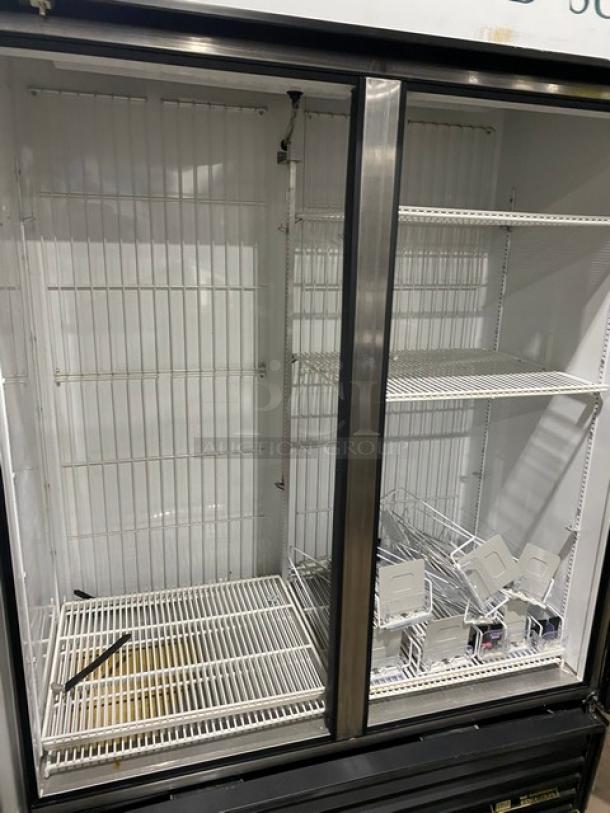 True GDM-49F double glass door merchandiser freezer, poly-coated wire racks, model number visible, used condition.