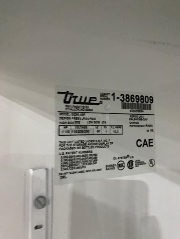 True GDM-49F commercial freezer label, SN: 1-3869809, 115/208-230V, 1 phase, detailing model and energy specs.