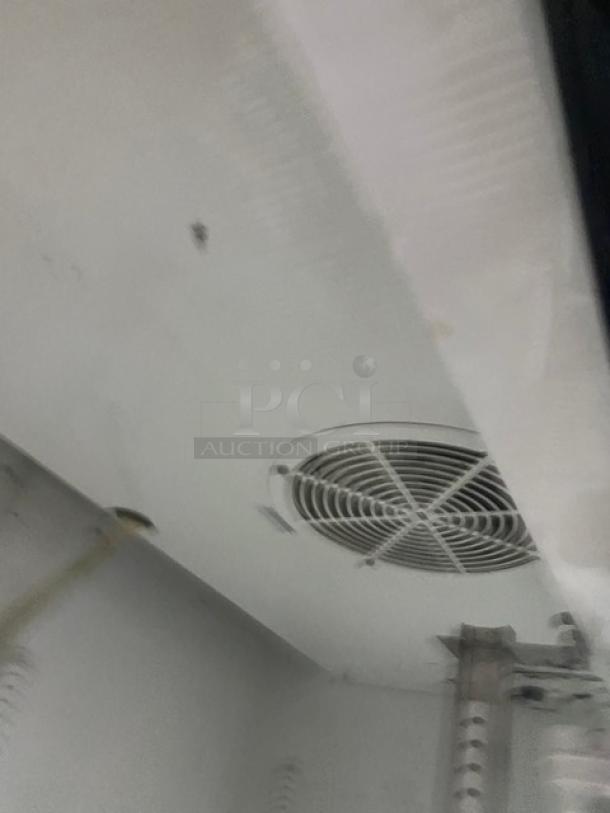 True GDM-37 commercial refrigerator interior view with fan. Poly-coated wired racks not visible. Model SN: 1-4753863.