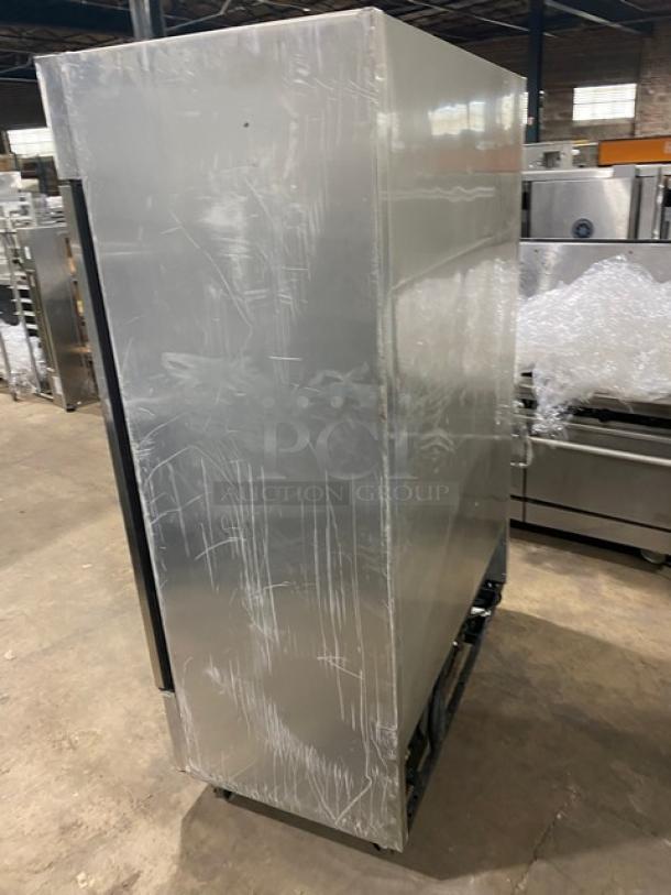 True T-49F commercial stainless steel 2-door reach-in freezer with poly-coated wire rack, on casters, showing some wear.
