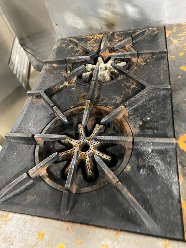 Garland stainless steel 2-burner range with flat plate, split-top, showing rust and wear, for commercial kitchen use.