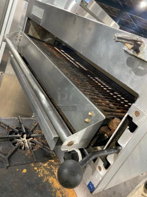 Garland stainless steel gas range with 2 burners, flat plate, oven, salamander broiler, wire rack, and backsplash.