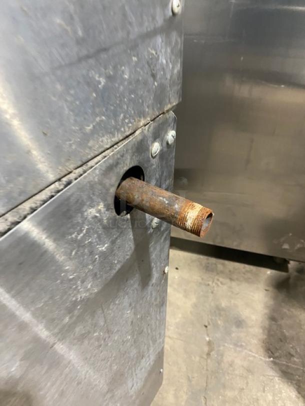 Alt text: Garland stainless steel commercial range connection point, showing natural gas inlet. Use with caution, visible wear.