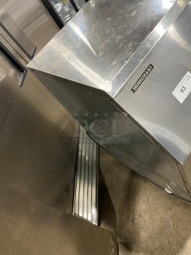 Hoshizaki stainless steel undercounter ice machine, sliding access door, on legs, with visible brand label.