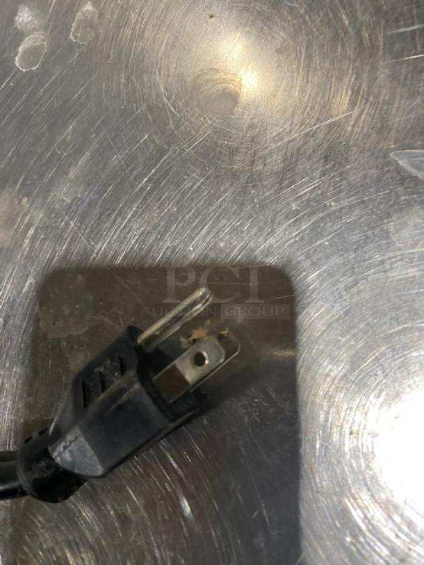 Hoshizaki stainless steel ice maker plug on brushed surface, showing standard electric connection.