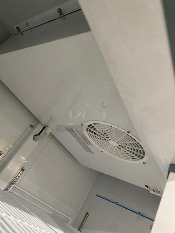 Arctic Air AF49EX commercial stainless steel freezer interior, poly-coated wire racks visible, pristine condition.