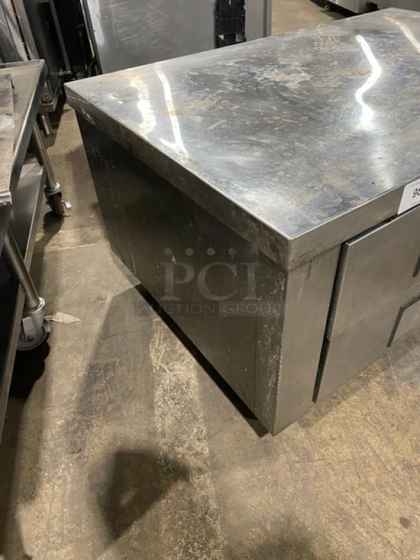 Commercial stainless steel refrigerated chef base with 2 drawers, on casters. Used condition, surface wear visible.