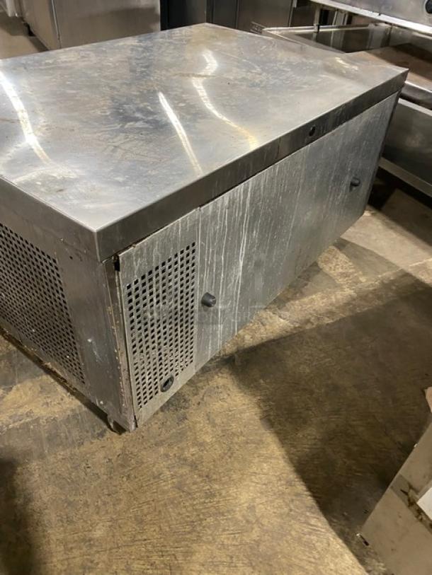 Commercial stainless steel 2-drawer refrigerated chef base on casters, showing surface wear and vented side panel.