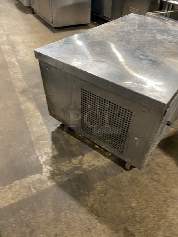 Commercial stainless steel 2-drawer refrigerated chef base on casters. Visible wear, suitable for kitchen use.