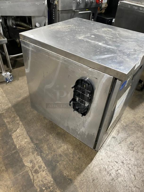 Randell stainless steel undercounter refrigerator with single solid door, poly-coated rack, and casters; visible wear.