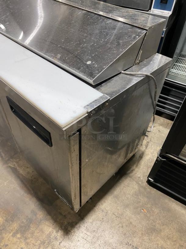Blue Air BAPT72 stainless steel 3-door refrigerated prep table with cutting board and poly-coated wire rack on casters.