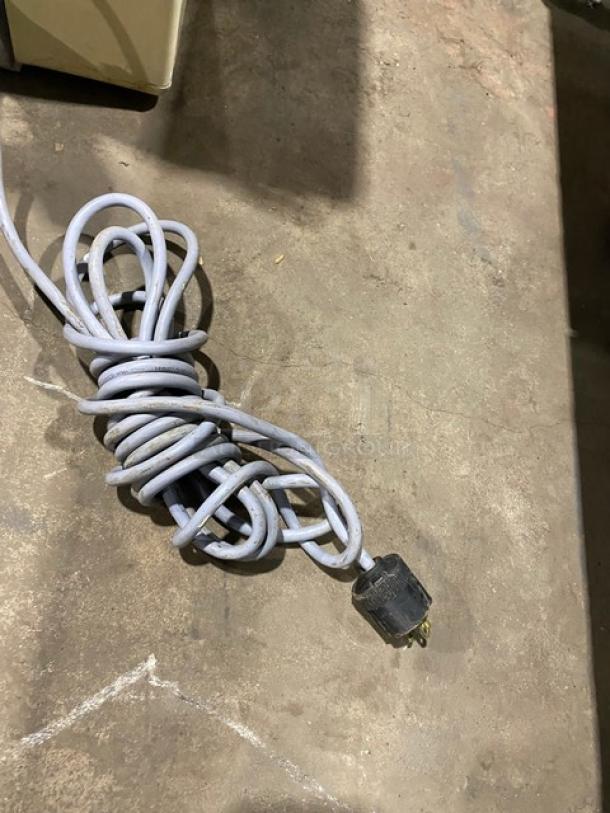 Anets electric countertop conveyor-belt dough roller power cord on concrete floor, showing moderate wear.
