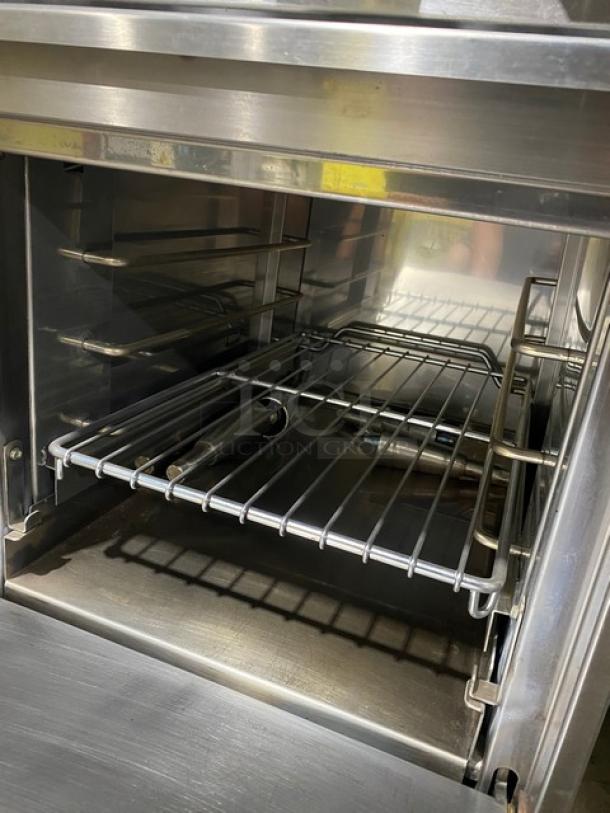Jade Range stainless steel natural gas 4-burner range/oven combo with wired oven rack and legs, shown in clean condition.
