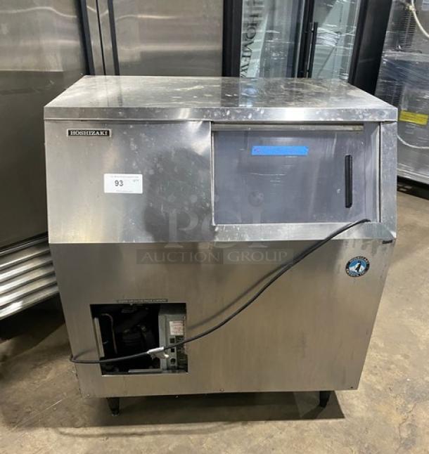 Hoshizaki stainless steel undercounter ice machine combo, electric powered, sliding access door, on legs, tag visible.