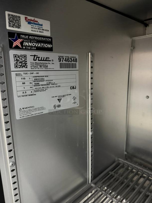 True TUC-24F-HC undercounter freezer interior with serial number 9746348. Features durable shelves, US-made innovation label, and specs.