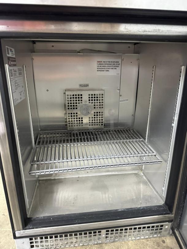 True TUC-24F-HC 24" undercounter freezer, stainless steel, tested and working, one door, internal racks, safety labels visible.