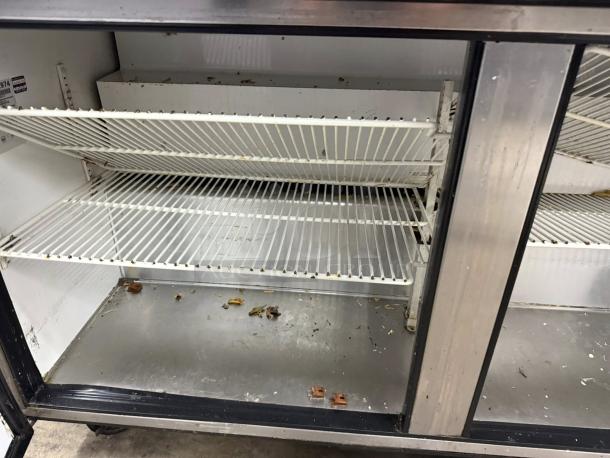 True TSSU-60-16 refrigerated prep table, stainless steel, dual doors, internal shelving, some visible residue, tested and working.