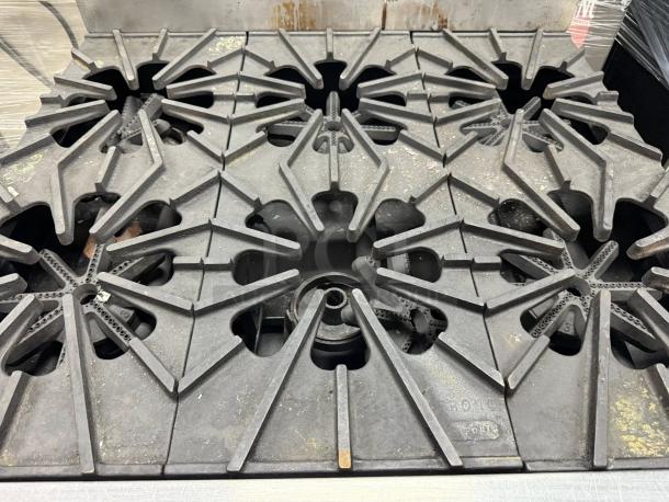Montague 6-burner gas range cooktop in excellent condition, showcasing sturdy cast iron grates and natural gas compatibility.