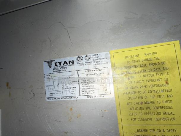 Titan XTSU72 72" 3-door sandwich prep table in great condition. Model and warning labels visible. 115v, 1ph, tested and working.