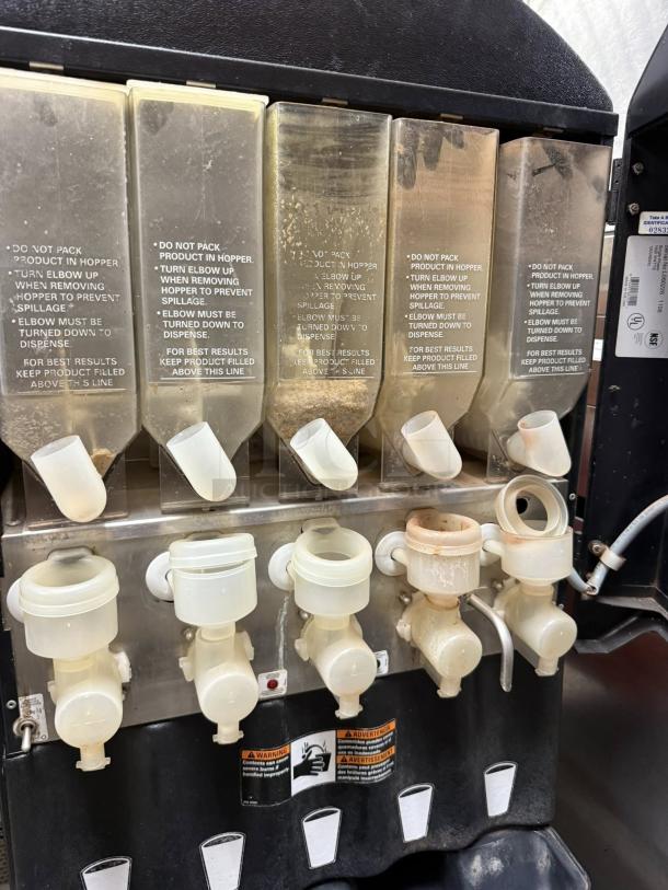 Grindmaster PIC5 dispenser showing five flavor hoppers, tested and working, with caution labels and 5 lb capacity each.