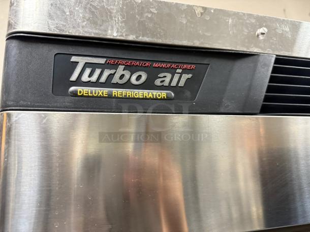 Turbo Air TSR-49SD-N6 refrigerator badge showcasing "Deluxe Refrigerator" label on stainless steel surface.