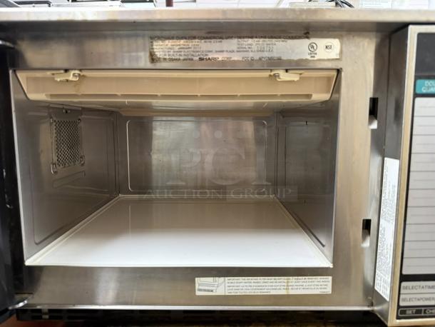 Sharp R-22GTF heavy-duty commercial microwave oven, 1200 watts, 120V. Tested and working. Stainless steel interior, visible UL label.