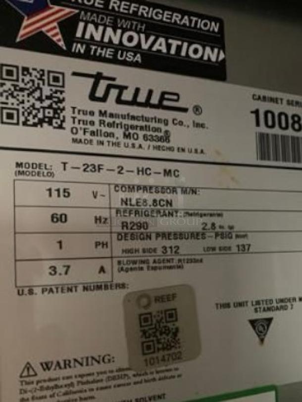 Label on True T-23F-HC freezer showing model, voltage (115V), refrigerant (R290), and design pressures, emphasizing U.S. manufacturing.
