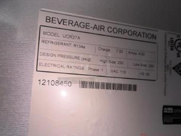 Label on Beverage-Air UCR27A undercounter refrigerator showing model, refrigerant R134a, pressure, and electrical specs.