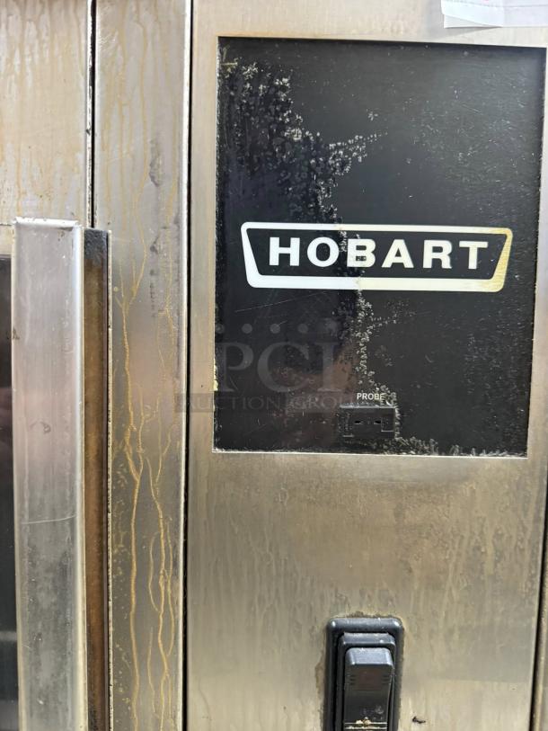Hobart HR7P electric rotisserie oven with visible wear. Features stainless steel exterior, model label, and working condition.