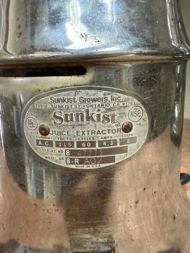 Sunkist J-1 commercial citrus juicer, 115V, 3450 RPM. Metal body, tested and working. Features manufacturer's label and model details.