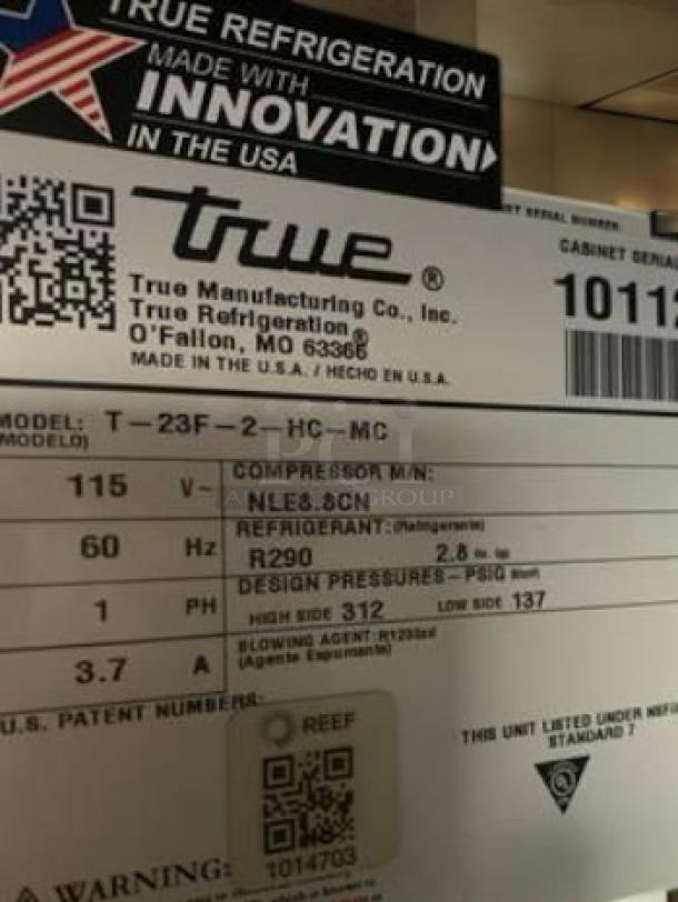 Alt text: "True T-23-HC single door reach-in refrigerator label showing model, voltage, and refrigerant details. Made in USA."