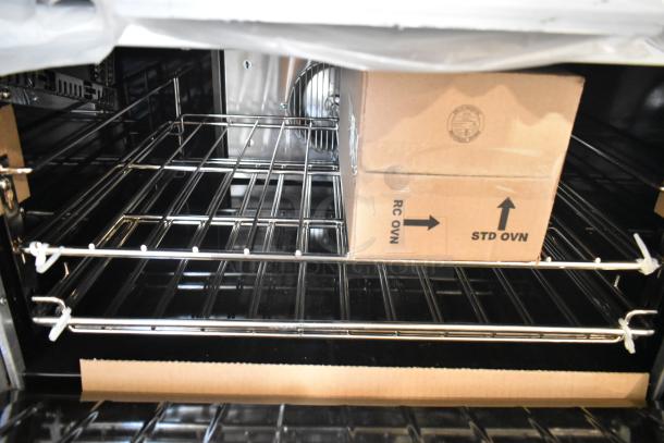 Interior view of a brand new Garland 372G366CN stainless steel convection oven with wire racks and a cardboard box inside.