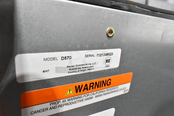 Brand new Manitowoc D570 stainless steel ice storage bin, 532 lb capacity, scratch and dent condition, model and warning labels visible.