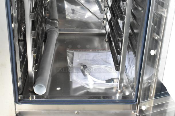 Brand new Bakers Pride AEHE061R stainless steel combi convection oven, 208V, 3 phase, visible accessories, and documents.