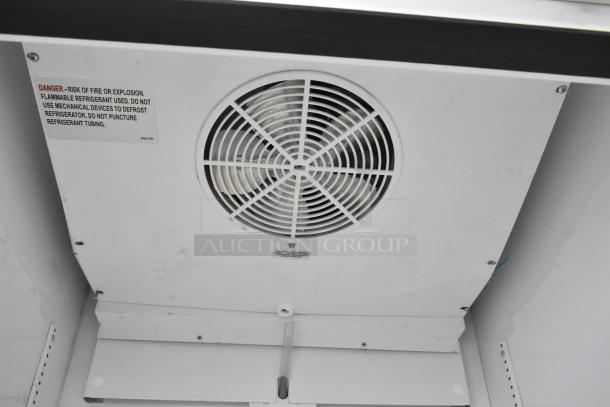 2021 True TSCI-600R-G-PH metal reach-in cooler with poly-coated racks, 115 volts, 1 phase. Interior fan and safety warning label visible.