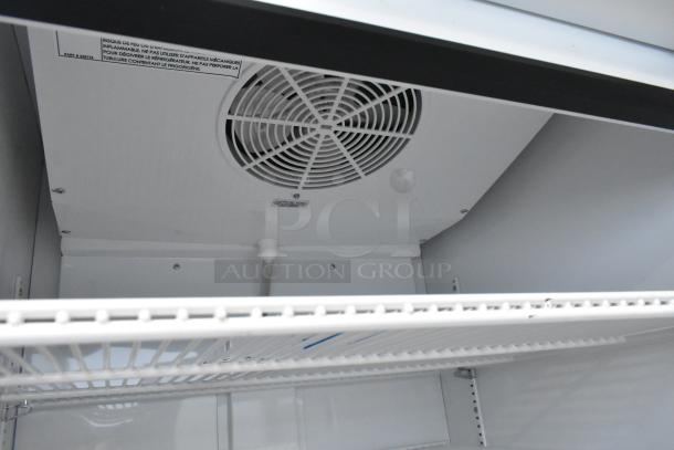 2021 True TSCI-600R-G-PH commercial single door cooler with poly coated racks, fan unit, and interior label visible.