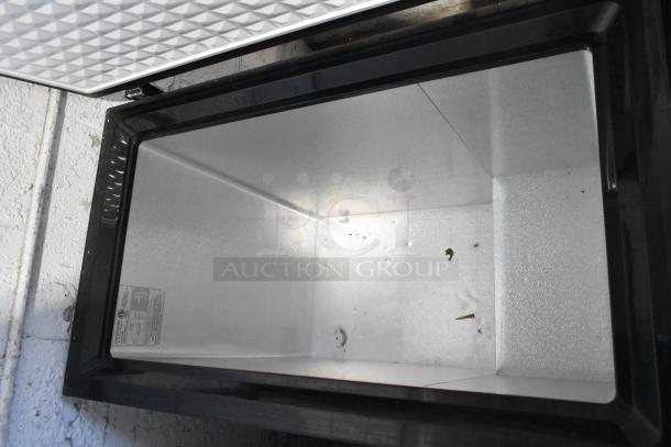 Frigidaire FGFRF7009-B-BLACK chest freezer, open lid, clean metal interior, 115 volts, 1 phase. Model label visible.