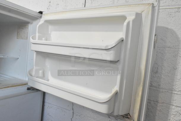 Frigidaire FRT21S6AWH metal cooler with freezer, 115 volts, 1 phase, white interior door shelves, some wear visible.