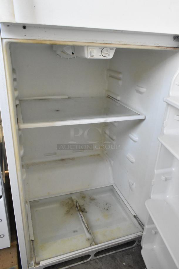 Frigidaire FRT21S6AWH metal cooler with freezer, 115 volts, 1 phase. Interior shows signs of wear; adjustable temperature control.