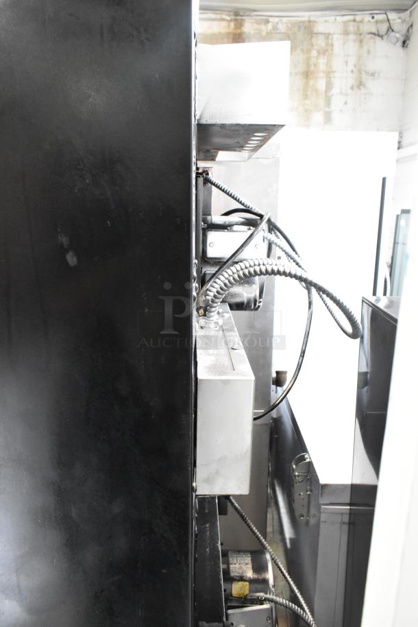 Side view of Garland stainless steel commercial convection ovens with visible wiring and metal structure detailing.