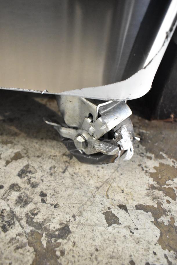 Blodgett commercial oven caster in focus, showing stainless steel build, attached to a full-size gas convection oven.